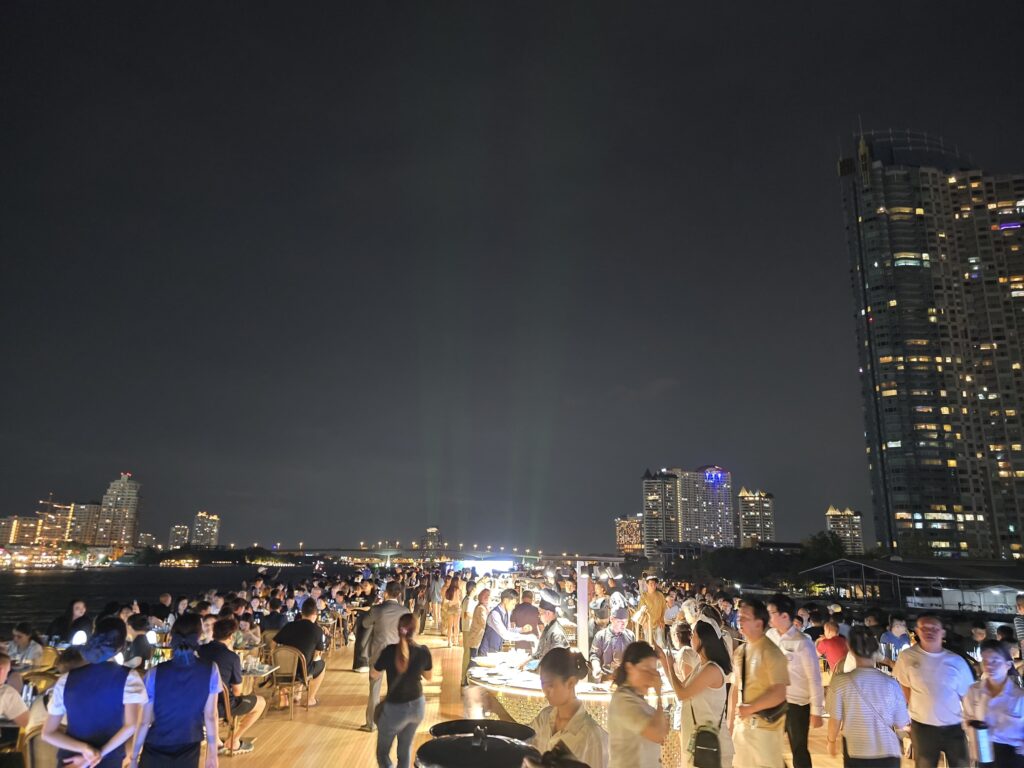 people are enjoying on the top deck of the cruise in Bangkok's Chao Pharaya river