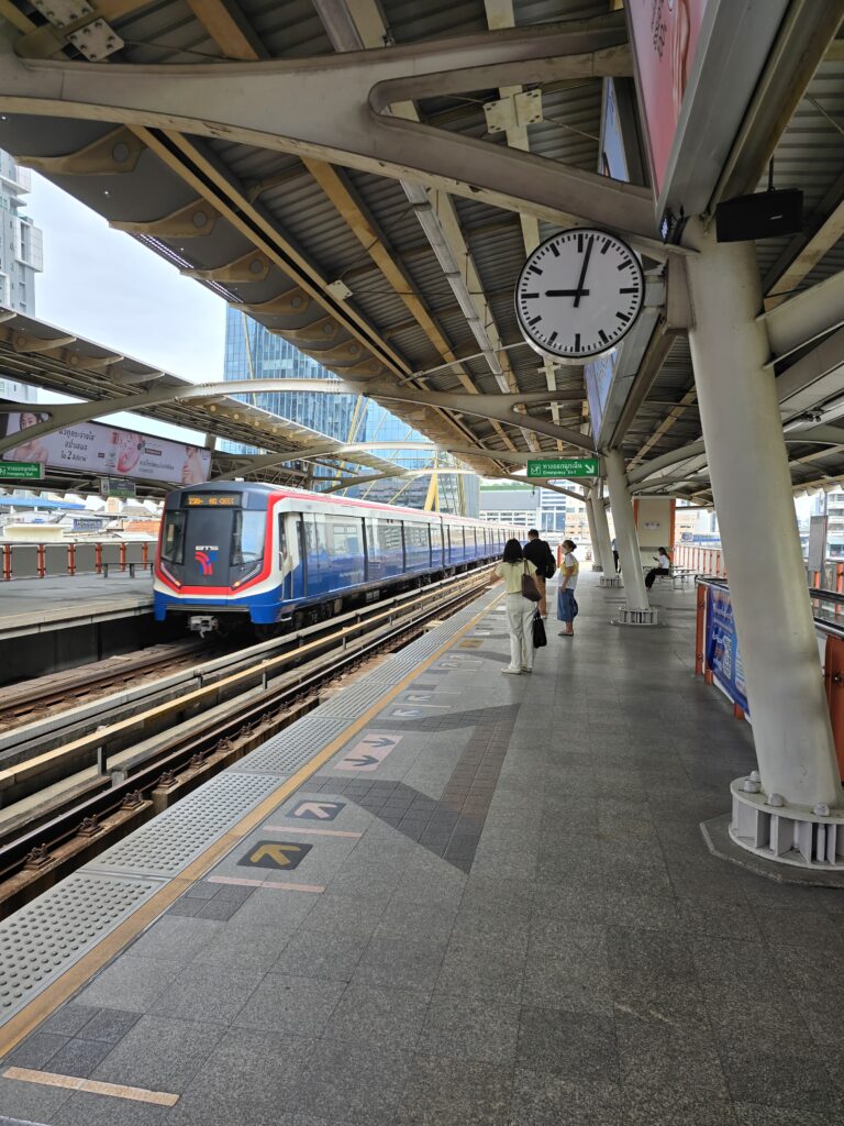 BTS sky train in Bangkok, arriving at a station.