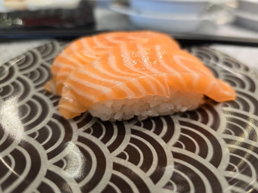 enjoying raw salmon sushi in a Japanese restaurant in Siam Premium outlets, Bangkok.