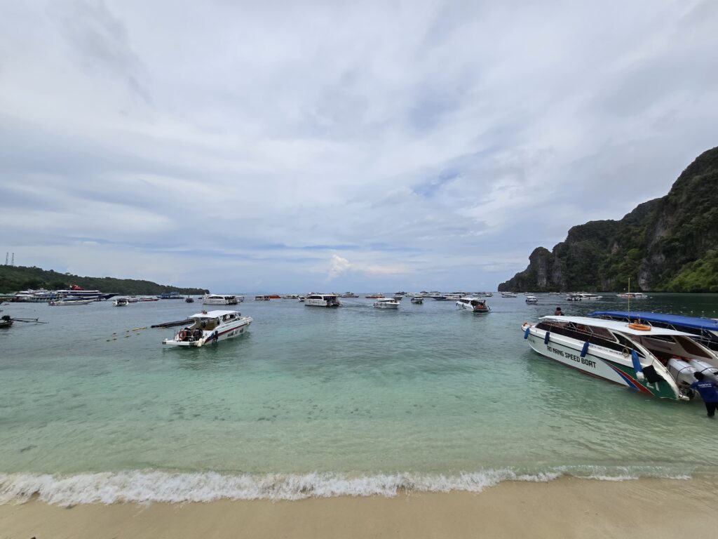 Thousands of tourists visit Phi Phi Island daily, as plenty of boats can be seen in the picture.